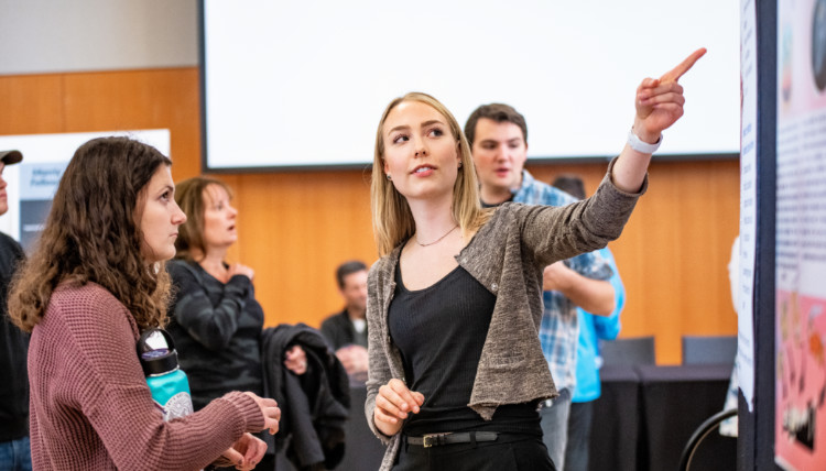 Statue of Bing Crosby behind fall yellow leaves. Gonzaga Will banner drapes the background.