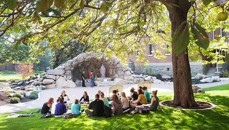 Students attend class outside near the grotto