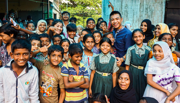 A Study Abroad student posing with a group of local citizens in his host country.