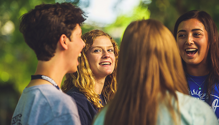 Student sharing with a small group her experience with undergraduate research