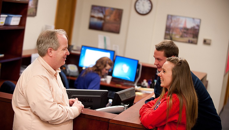 Students talking to a teacher.