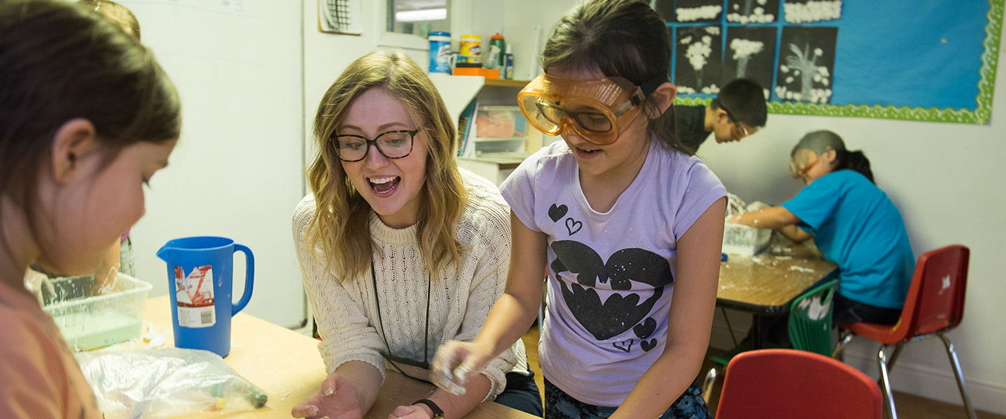 Gonzaga student instructor leads elementary students in science experiment.