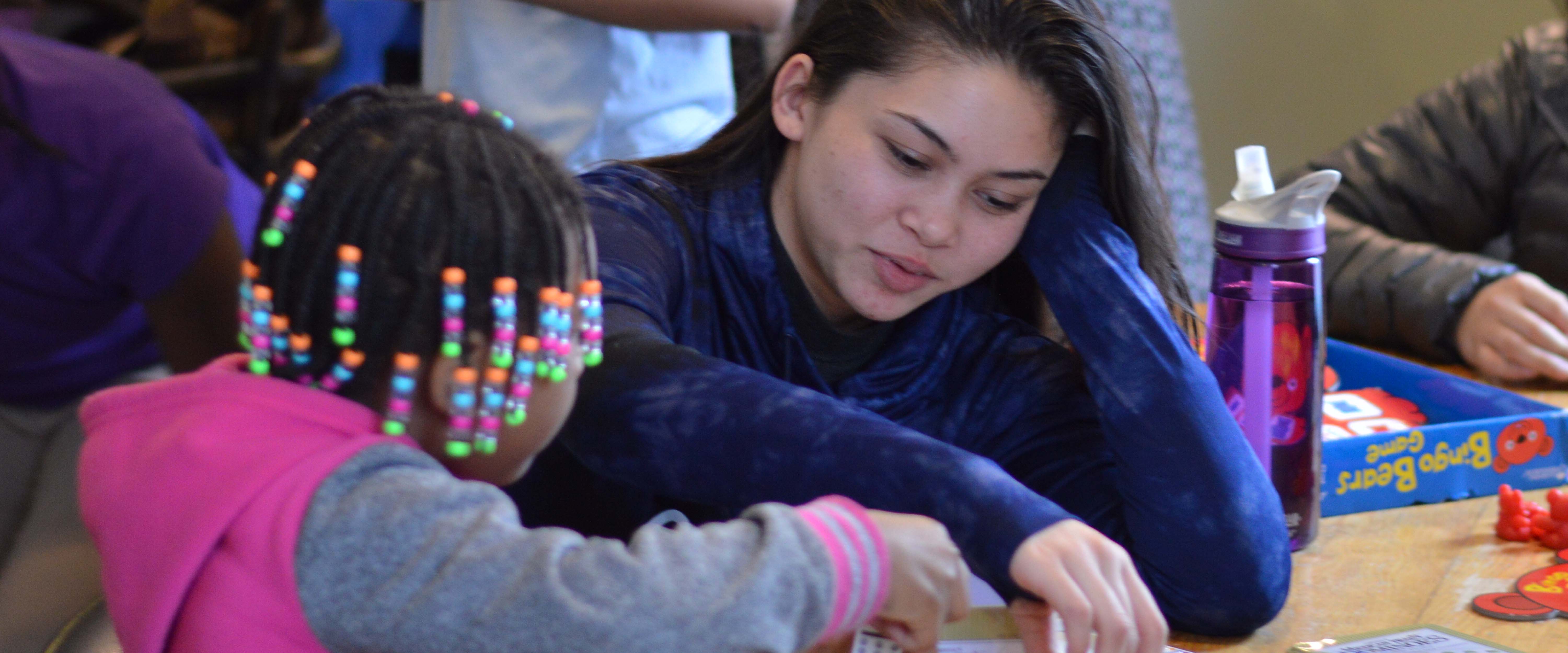 Gonzaga student playing a board game with youth
