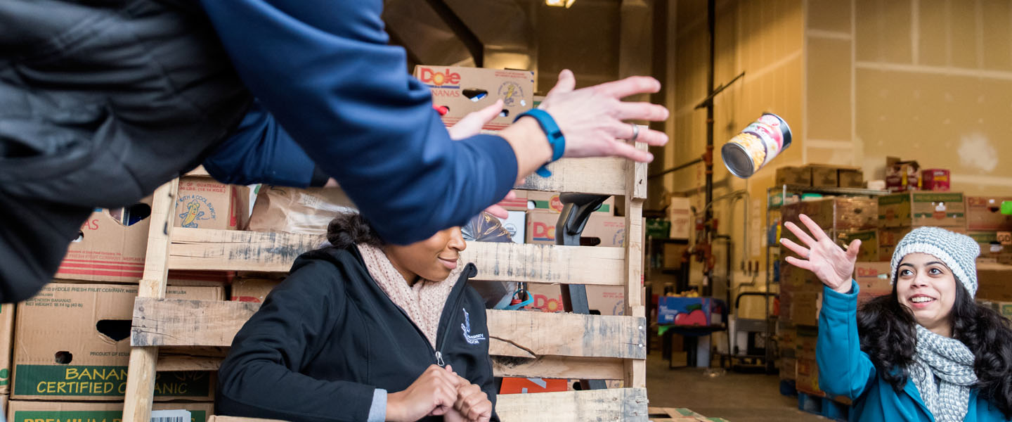 Volunteers passing food at food bank 