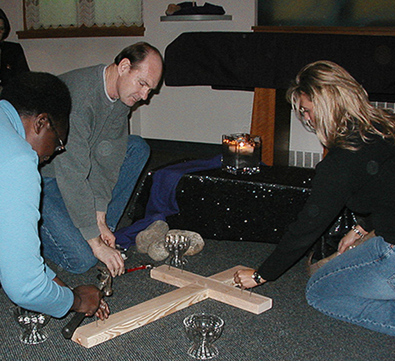 Members of the Ministry Institute hammer nails into the cross on Good Friday.