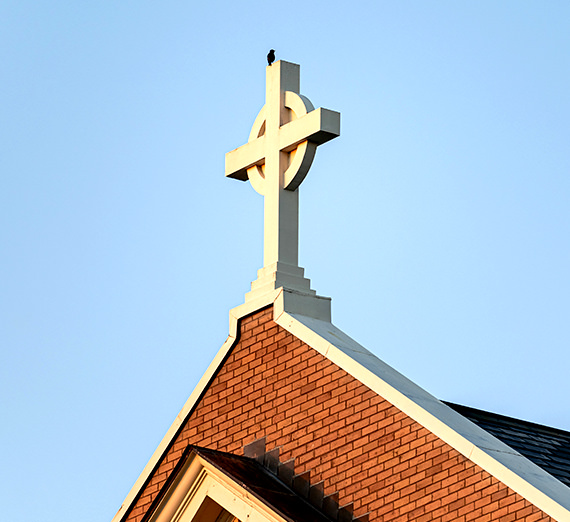 bird perched on cross
