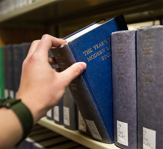 hand reaching for book on shelf