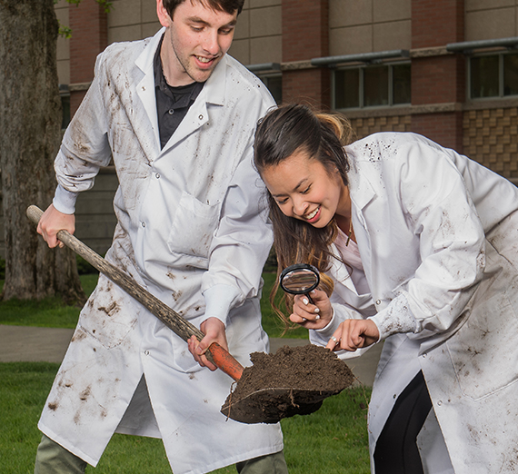 students look at dirt through magnifying glass