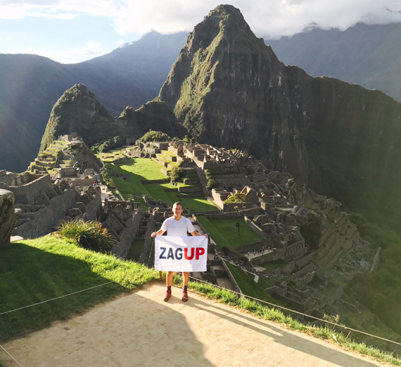 A Gonzaga student holding a ZagUp flag at Machu Picchu. Photo by Mason Matteoni