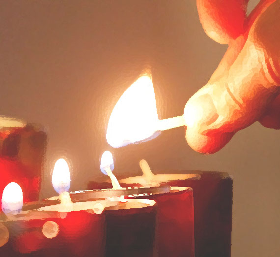 Prayer candle being lit by hand.