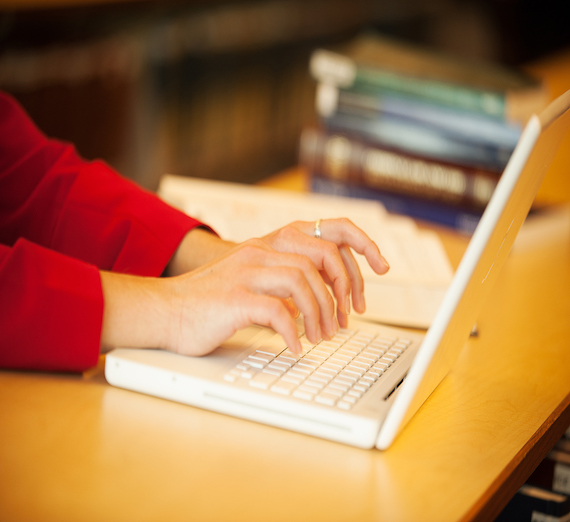 Woman smiles while using a laptop