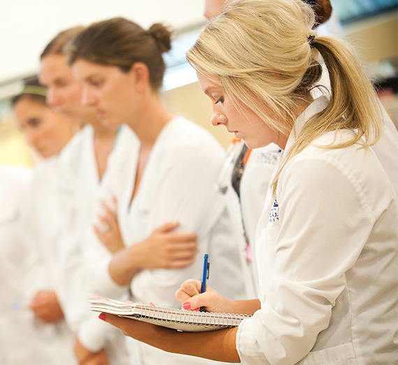 Undergraduate nursing student taking notes in the Sim Lab.