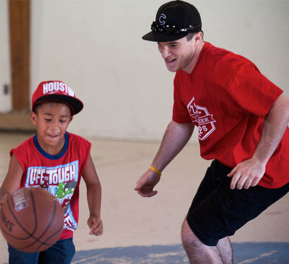 volunteer playing basketball with kids 