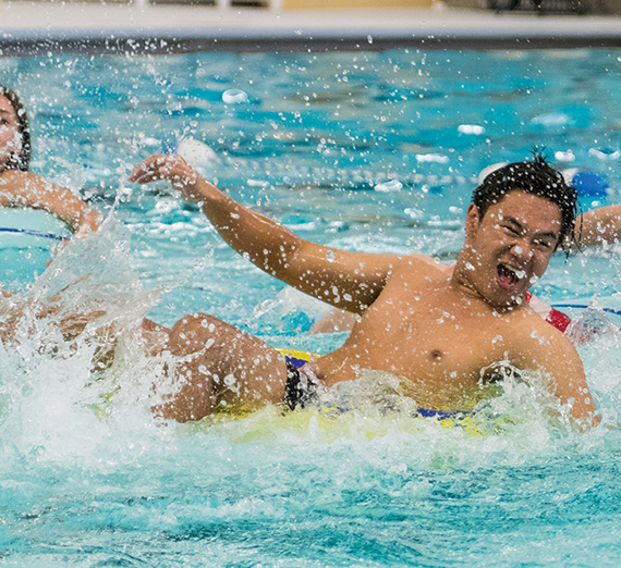 GU student plays inner tube basketball in the pool