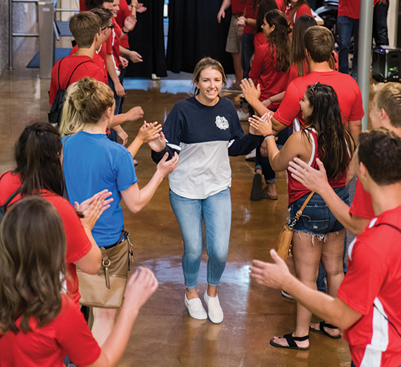 GU student runs through a tunnel of students giving her a high-five