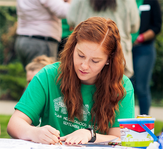 A student colors sheets at the Logan Block Party