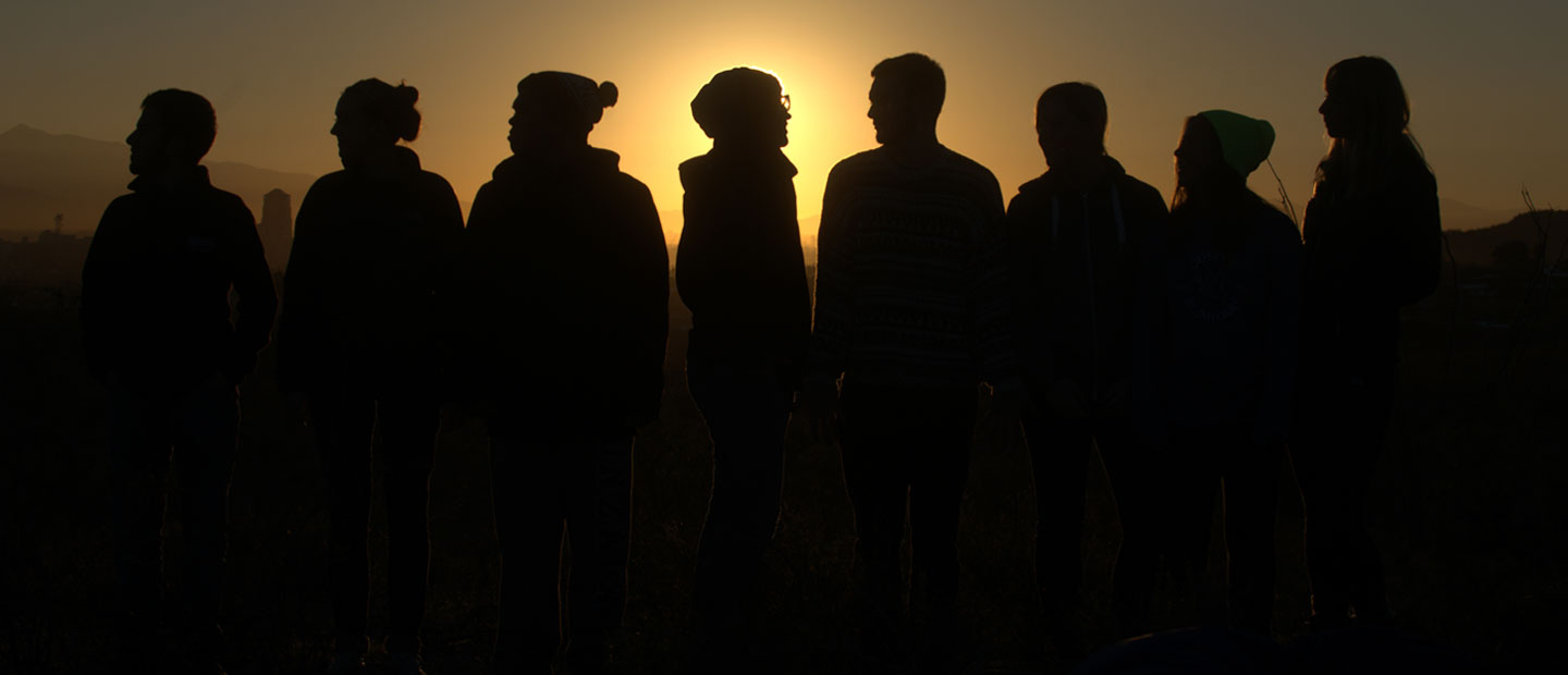 students silhouetted by sunset
