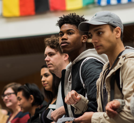 Students stand together with linked arms on International Day of tolerance.