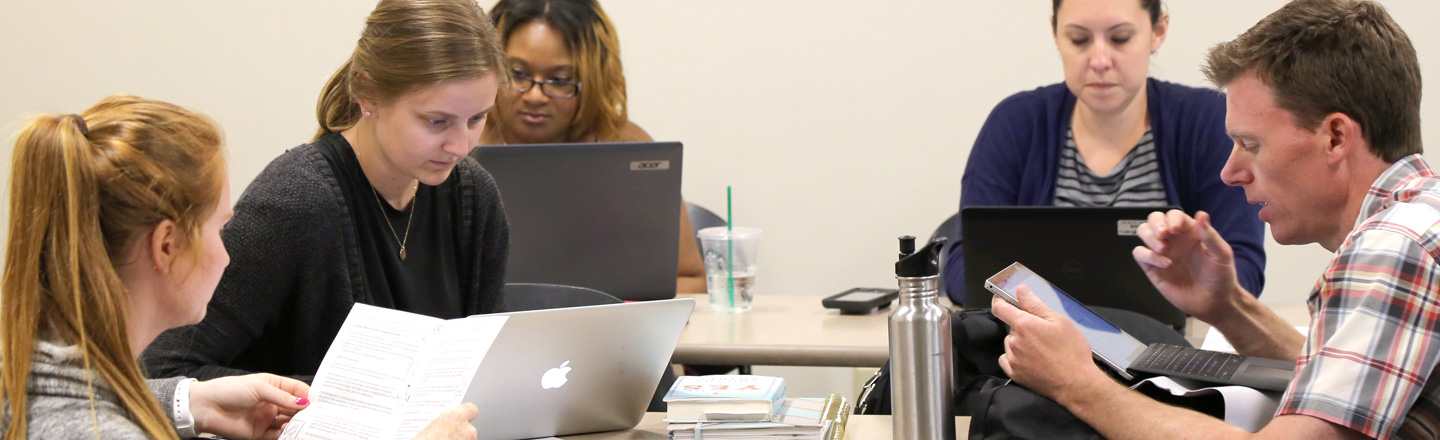 Students on computers discussing strategy