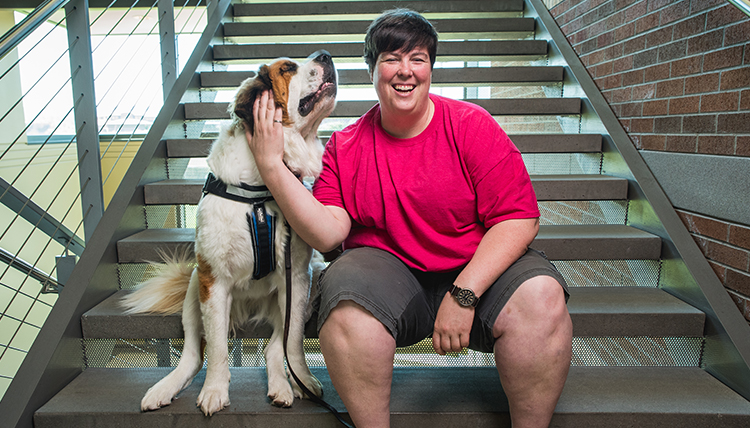 Dee Dee Brown pets Lucy the dog on the Herak stairs.