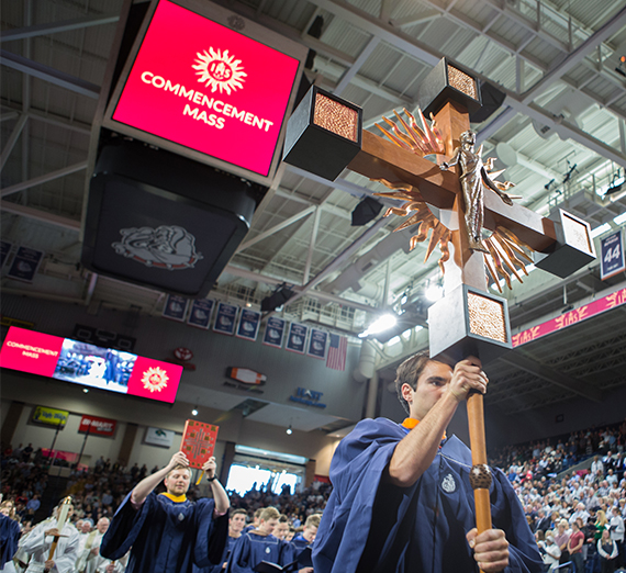 student walks with large cross in Mass processional