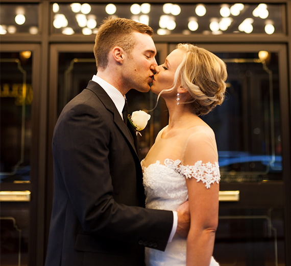 Jordan Travis and Derek Peterson embrace for a wedding photo
