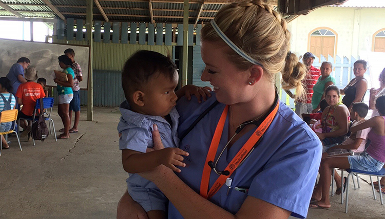 Carly Duffy holds baby seeking medical attention and smiles at him