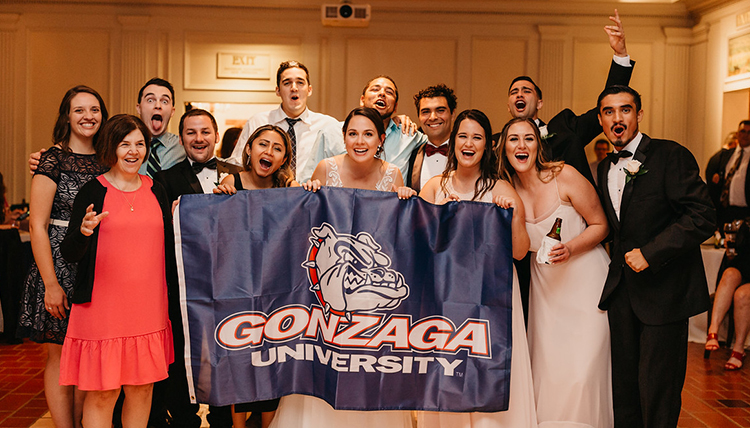 family gather around couple with GU flag