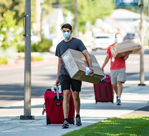 a student and family member haul items to a dorm