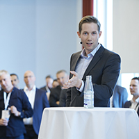 Gonzaga alumni Kevin O'Toole stands at a table in front of an audience.