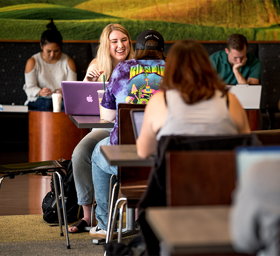 Students study at tables and benches in the Hemmingson student center. 