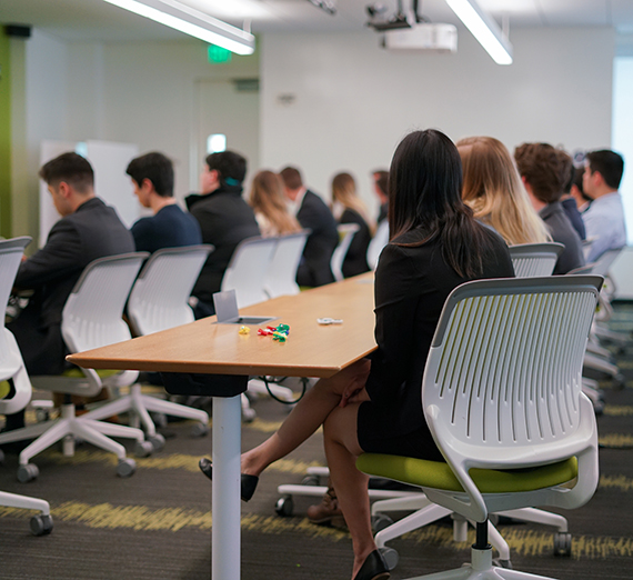 People sitting in chairs at a business meeting.