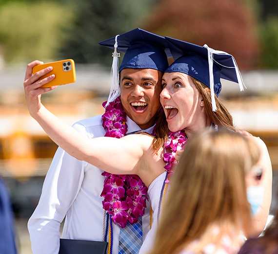 two graduates taking a selfie