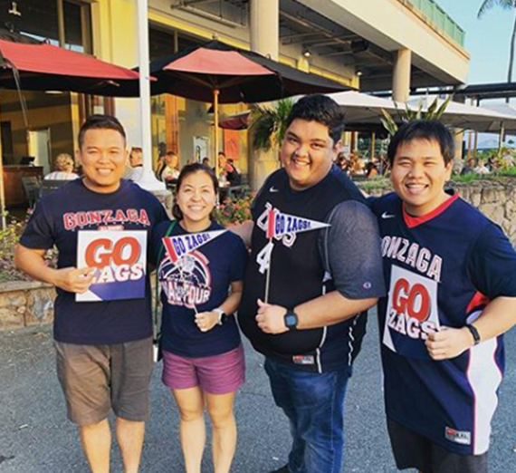 4 people hold go zags signs in hawaii