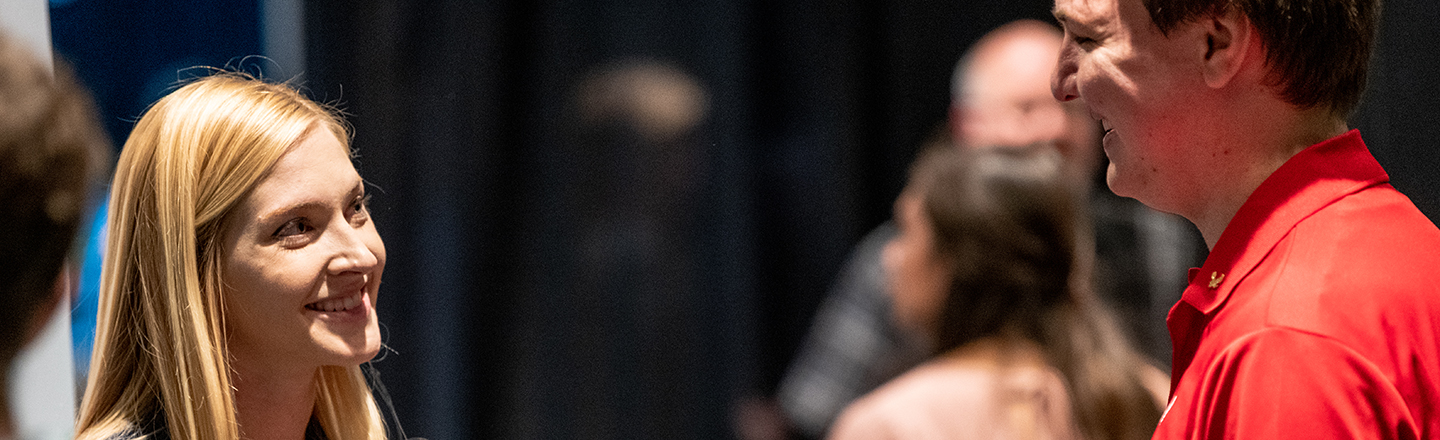 Woman to the left and man to the right, both smiling