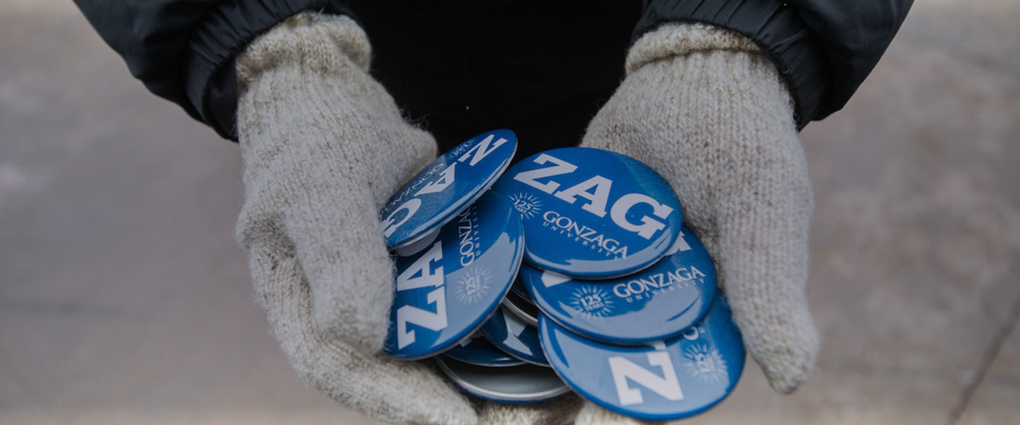 Person holding Zag buttons.