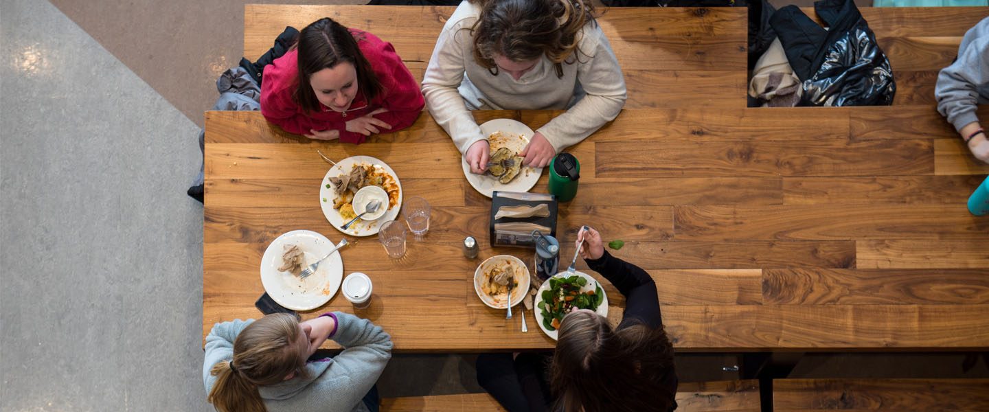 Studentes eating at a table in the dining hall 